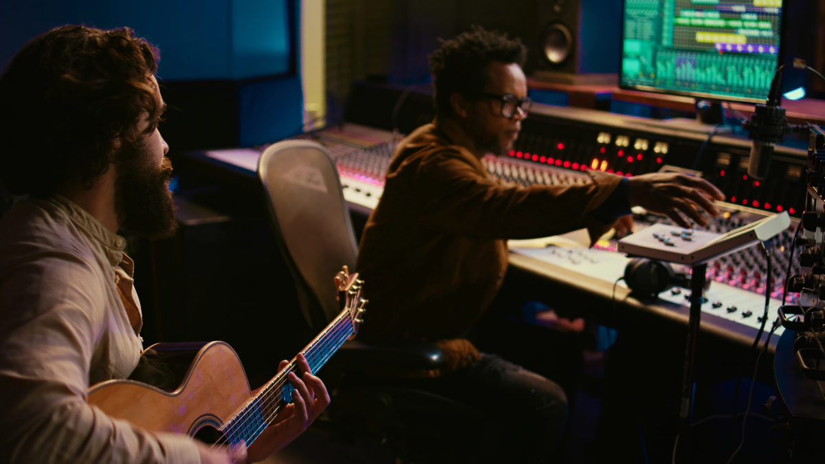 A man playing a guitar in a studio