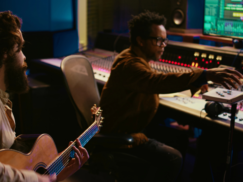 A man playing a guitar in a studio