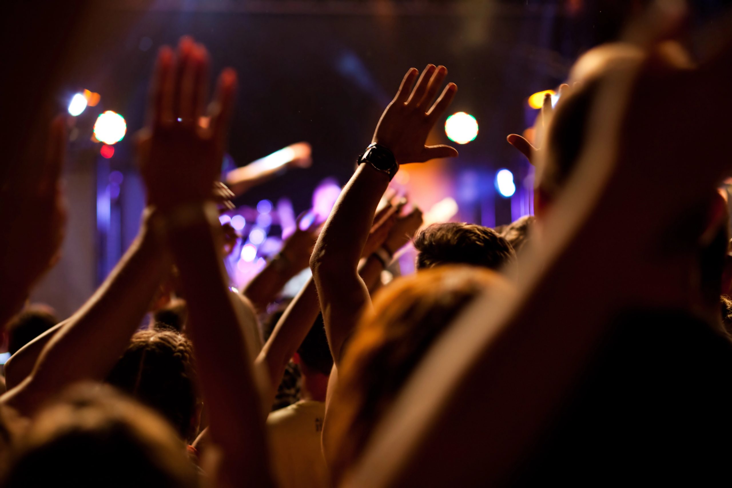 A crowd with their hands up at a concert
